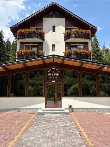 a building with flower boxes on top of it at PENSIUNEA SKY HUB in Arieşeni