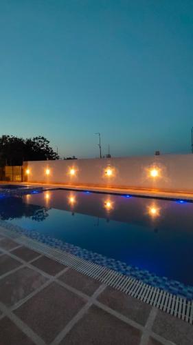 a swimming pool at night with lights around it at Urban Dhani in Gurgaon