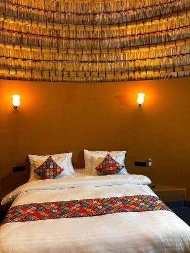 a bedroom with a large bed with two pillows at Urban Dhani in Gurgaon