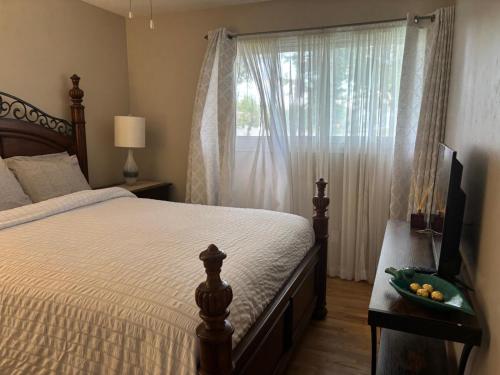 a bedroom with a bed and a window with a bowl of fruit at Three Pines Private Bedroom Suite in Moncton