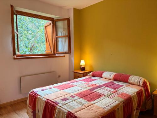 a bedroom with a bed and a window at Ambiente de montaña- Chimenea, vistas y jardín- Isard 4 in Pla de l'Ermita