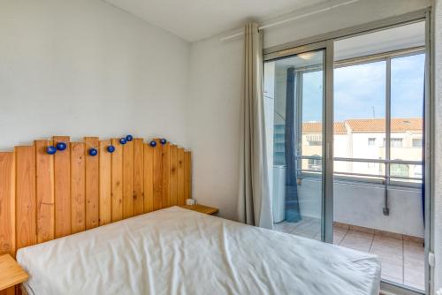 a bedroom with a bed and a large window at L'escale Marine Air-conditioning in Sète