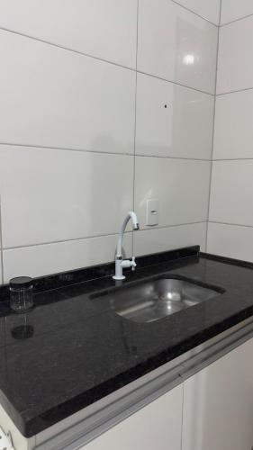 a black counter top with a sink in a kitchen at Apartamento Completo Próximo a BR in Biguaçu