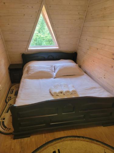 a bed in a room with two towels on it at Горянка in Guta