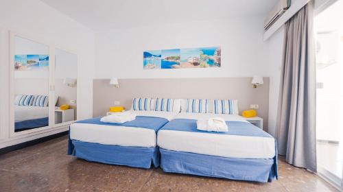a bedroom with two beds and a large mirror at htop Caleta Palace - Bliss in Platja d'Aro