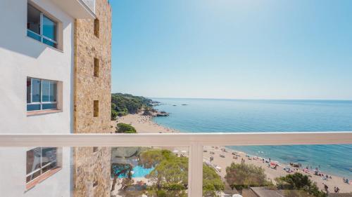 a view of the beach from the balcony of a building at htop Caleta Palace - Bliss in Platja d'Aro