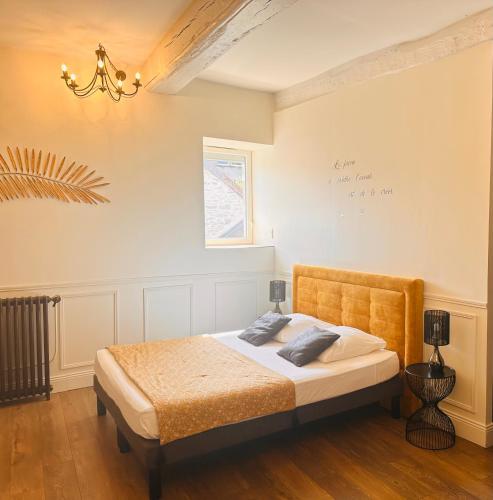 a bedroom with a bed and a chandelier at Gite de Bourgogne in Sainte-Marie-sur-Ouche