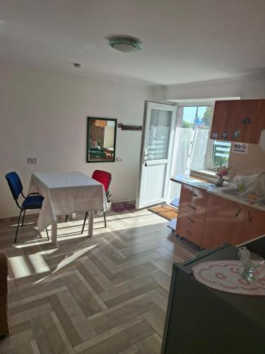 a living room with a table and a kitchen at Gardenhouse in Mëmëlisht