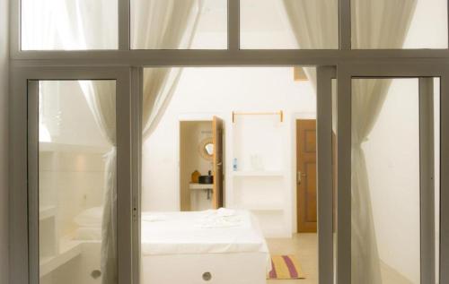 a bedroom with a white bed and a window at Lilo House in Watamu