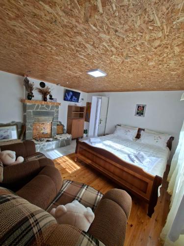 a bedroom with a large bed and a fireplace at Gardenhouse in Mëmëlisht