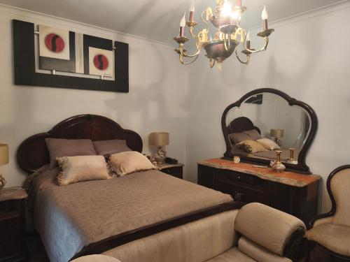 a bedroom with a bed and a mirror and a chair at Orion Guest Villa Casais in Lousada