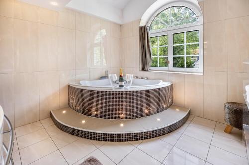 a bathroom with a tub with a window at Exklusive Traumvilla mit Sauna in Hamburg