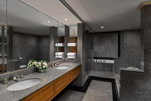 a bathroom with two sinks and a large mirror at Montien Riverside Hotel Bangkok in Bangkok