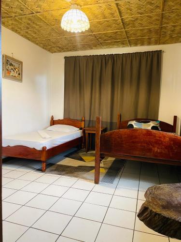 a room with two beds in a room with a ceiling at Screaming Gecko Hostel in Busuanga