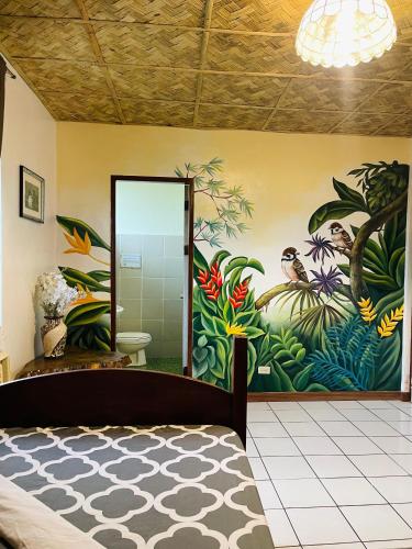 a bedroom with a painting on the wall at Screaming Gecko Hostel in Busuanga