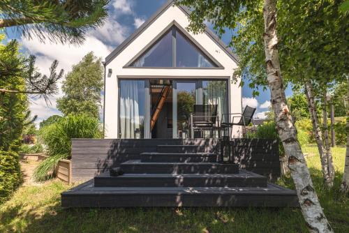 a small house with glass doors and stairs at Osada Marchowo in Kielno