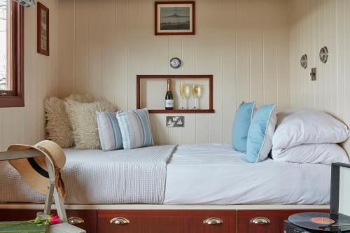 a bedroom with a bed with blue and white pillows at Lens Hut in Masbury Station
