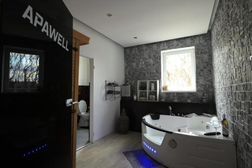 a bathroom with a bath tub and a toilet at Apartmán Elarys in Nezdenice