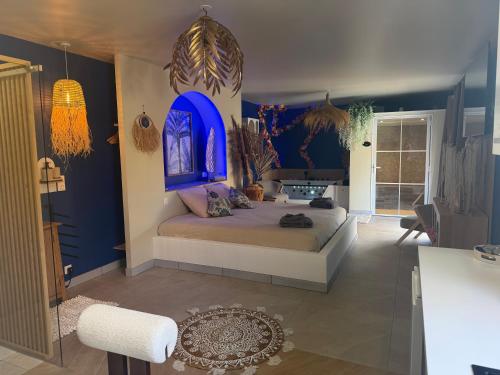 a bedroom with a bed with a blue wall at gîte romantique in Etalondes-la-Pipe