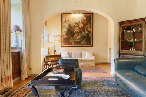 a living room with a couch and a painting on the wall at Villa Pian dei Giullari con Piscina in Florence