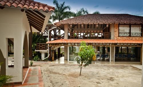 a large house with a building with a roof at Hotel Boutique Villas de San Sebastián in Villavicencio