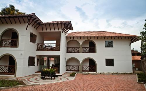 a large white house with a red roof at Hotel Boutique Villas de San Sebastián in Villavicencio