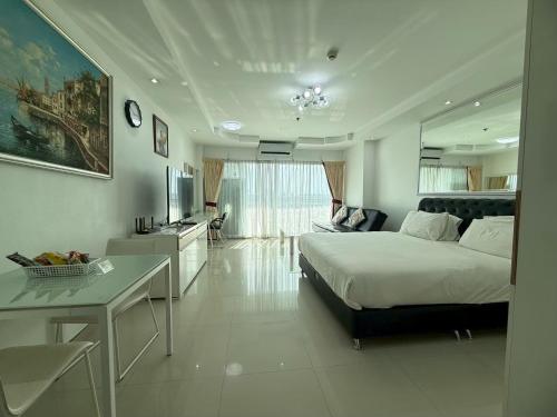 a bedroom with a bed and a living room at View Talay 6 Pattaya Beach Apartment by Honey in Pattaya