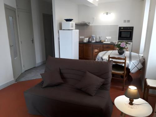 a living room with a couch and a kitchen at Gîte la Roche du Gravillot in Château-Chinon