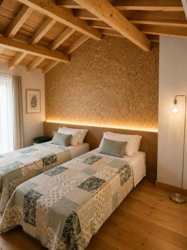two beds in a room with wooden floors at Ductus Aquae House in Évora