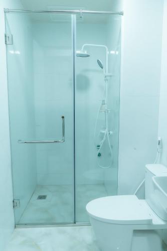 a bathroom with a glass shower and a toilet at T&T Luxury Hotel Đồi Ngô in Bắc Ninh