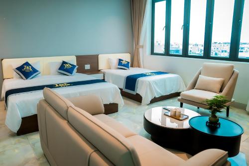 a hotel room with two beds and a couch at T&T Luxury Hotel Đồi Ngô in Bắc Ninh
