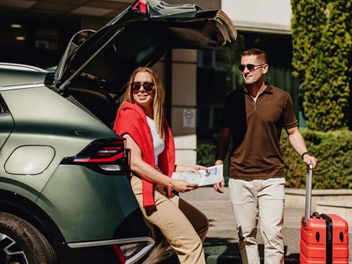 a man and a woman getting out of a car at Ibis Győr in Győr