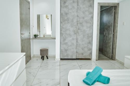 a white bathroom with blue towels on a bed at Nissi Avenue Suites in Ayia Napa