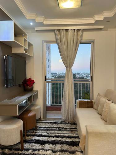 a living room with a couch and a large window at Cozy Place Curitiba in Curitiba