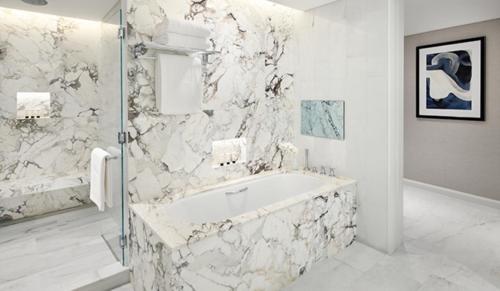 a white bathroom with a tub and a shower at Address Dubai Mall in Dubai