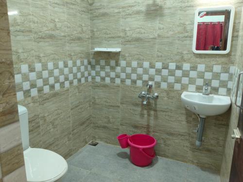 a bathroom with a sink and a toilet at Malar Residency in Tirunallār