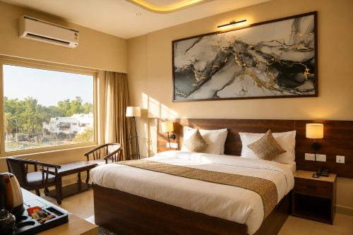 a hotel room with a bed and a desk and a window at The Park Central in Lucknow