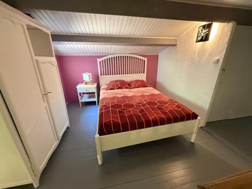 a bedroom with a bed with a red comforter at Villa La Marpierre in Mondragon