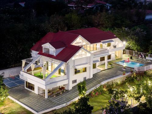 an aerial view of a house with a swimming pool at EKOSTAY Luxe - Noah Villa with Peddle Court & Sunset View in Lonavala