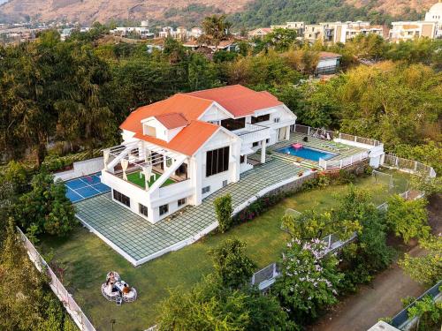 an aerial view of a house with a swimming pool at EKOSTAY Luxe - Noah Villa with Peddle Court & Sunset View in Lonavala