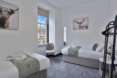 a bedroom with two beds and a chair and a window at Contractor-Friendly - Hawick - Free Parking - 2BR in Hawick