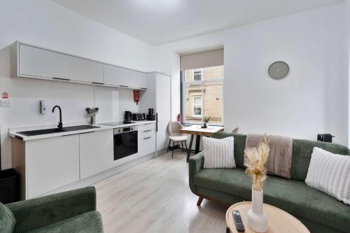 a living room with a couch and a kitchen at Contractor-Friendly - Hawick - Free Parking - 2BR in Hawick