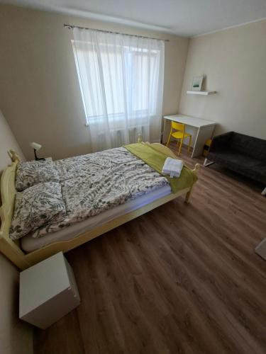 a bedroom with a bed and a desk and a window at Dom na Kościelnej in Ślesin