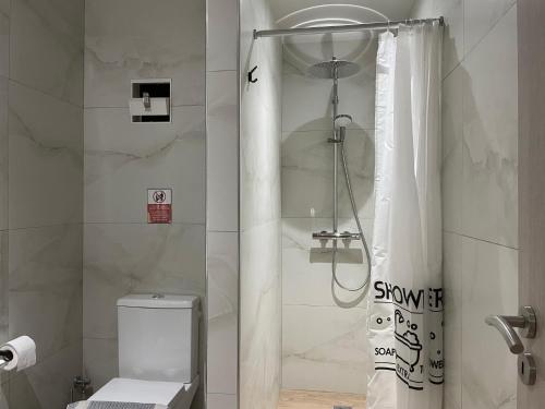 a bathroom with a shower with a toilet and a shower curtain at SAN REMO HOSTEL in Athens