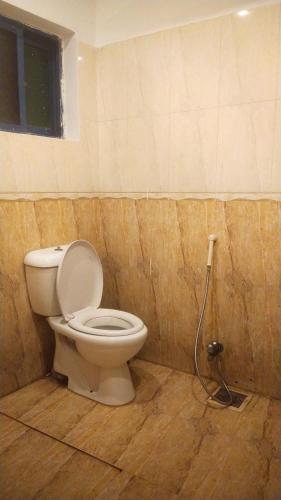 a bathroom with a toilet with a hose at Swiss Pearl Hotel Lahore in Lahore