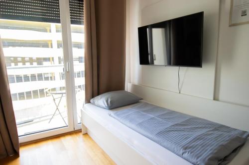 a room with a bed and a flat screen tv at MyRoom - Top Munich Serviced Apartments in Munich