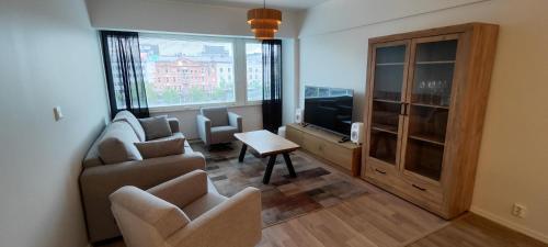 a living room with a couch and chairs and a tv at Ylätori 2A in Vaasa