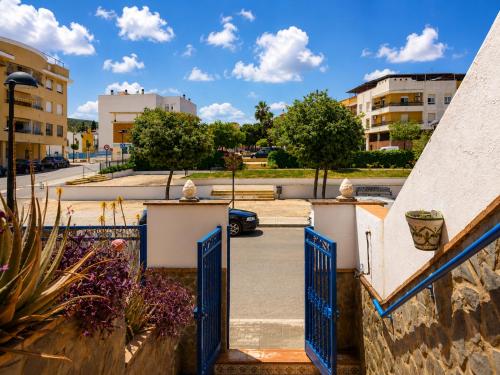 an entrance to a parking lot with a blue gate at La Aracelitana in Lucena