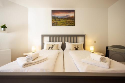 a bedroom with two beds with white sheets and towels at Ferienwohnung Panoramablick - super für deine Familie und die besten Aussicht in ganz Todtmoos in Todtmoos