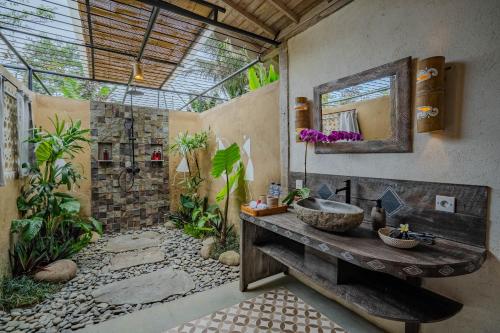 a bathroom with a sink and a mirror at Sacred Padi Ubud Villa in Payangan